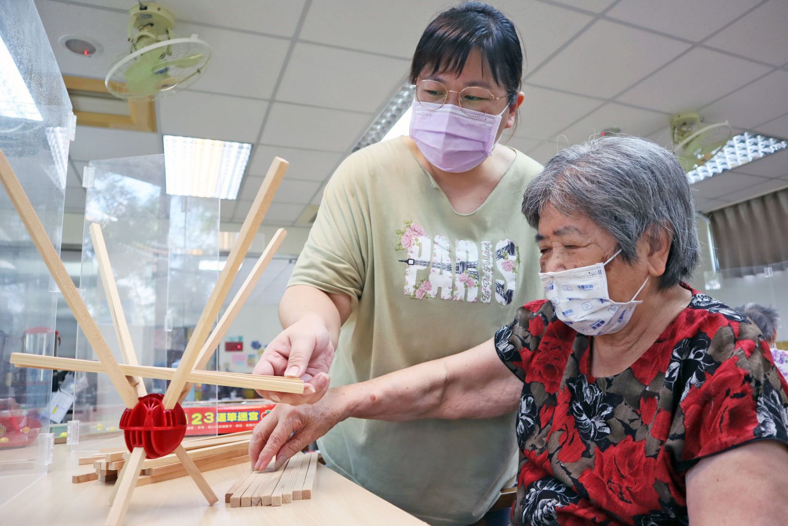阿隨阿嬤在日照中心跟著照服員的引導下，遊戲中也能訓練精細動作、手眼協調