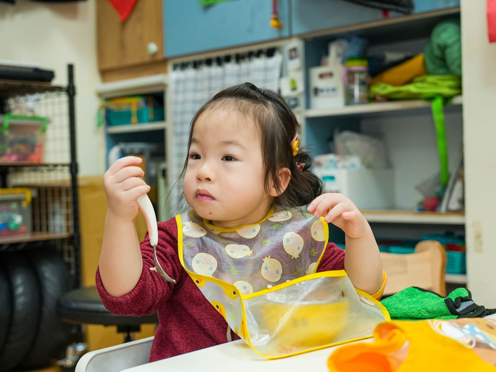 慢飛天使小芯來到日托班後，開始練習自己拿湯匙吃飯。